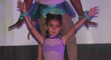 dogtertjie in dansklere met haar ams omhoog