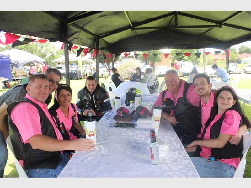 bikers in pink sit around a table