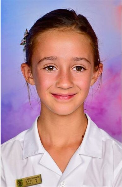 girl in school uniform with badge in her pocket