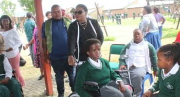 woman pushes learner in a wheelchair