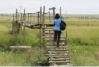 a woman climbs onto a home made bridge