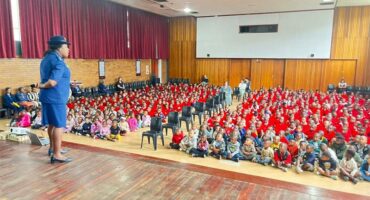 police woman speaks to learners in a school hall