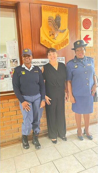 Two police officers and a civilian in a school hall