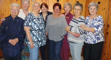 group of people in front of a wooden wall