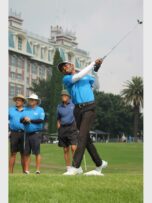 a black man swings his golf club