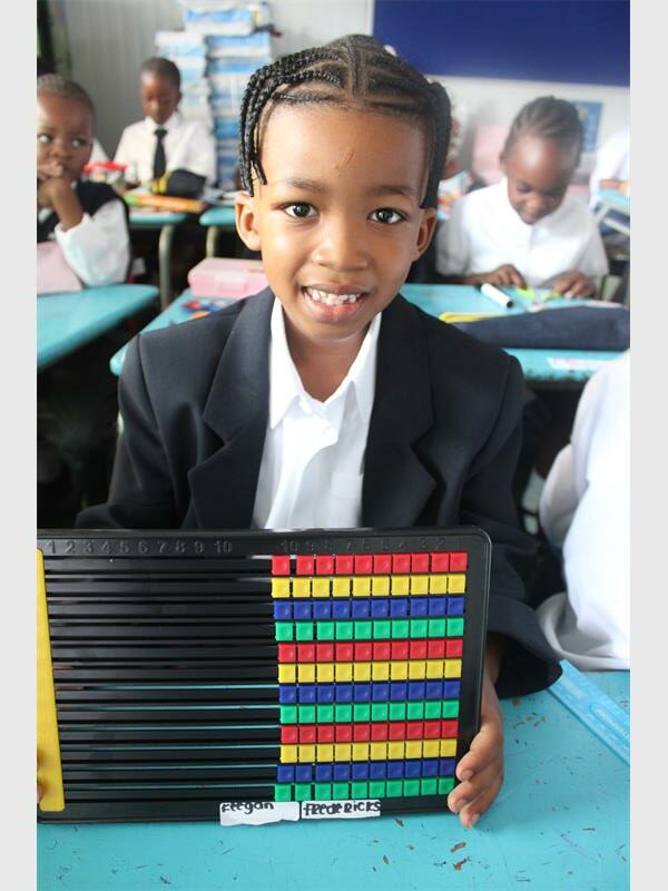 boy in blue blazer holds an abacus