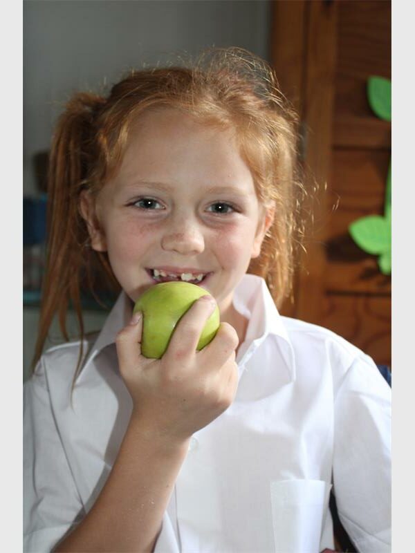 red haired girl bites into an apple