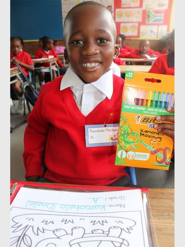 grade 1 boy holds up crayons