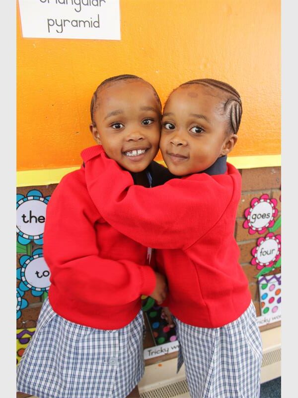 twin girls in red and blue school uniforms