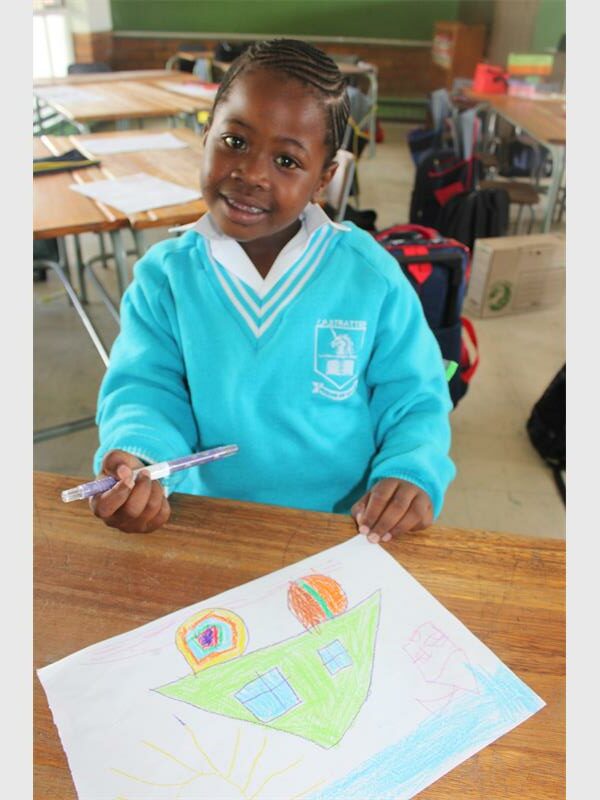 girl in light blue uniform drawing a picture