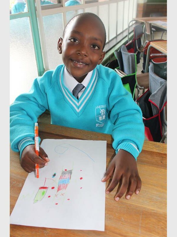 boy in light blue uniform drawing a picture