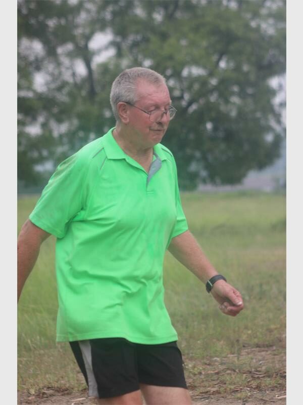 man with bright green shirt walking in the park