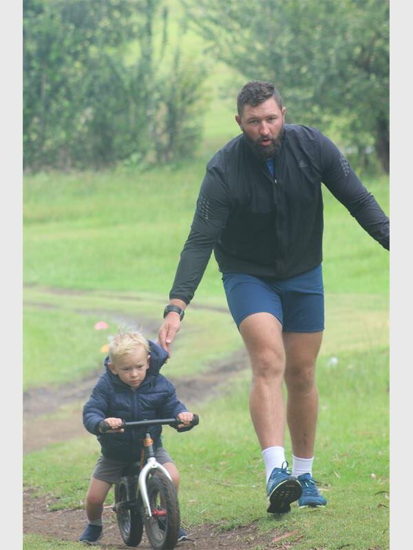 Father holds up his son riding a bicycle