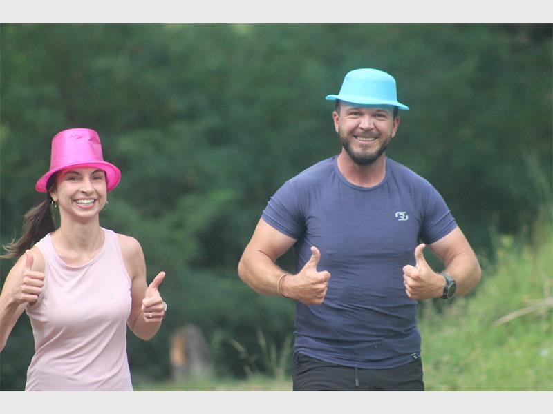 woman and man running while wearing party hats