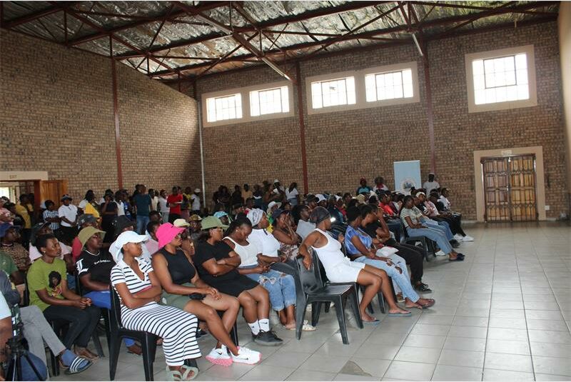 people sitting on chairs in a large hall