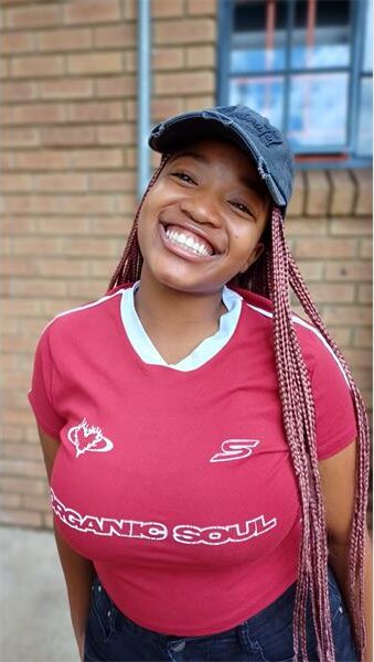 girl with long braids, red t-shirt and a baseball cap