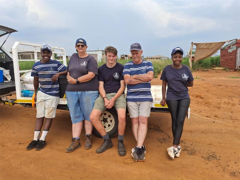 five people at a bakkie in the township