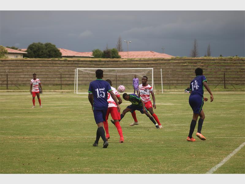 soccer players battle for the ball