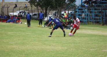 soccer players battle for the ball