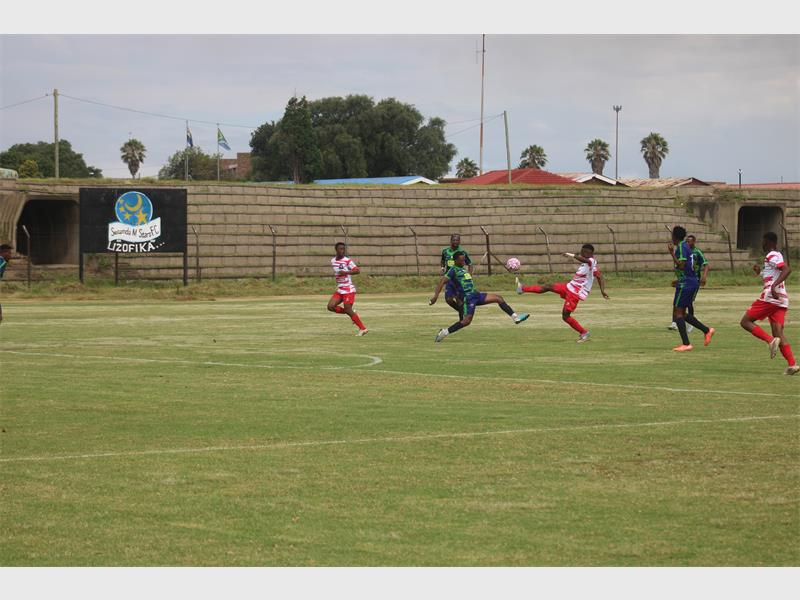 soccer players battle for the ball