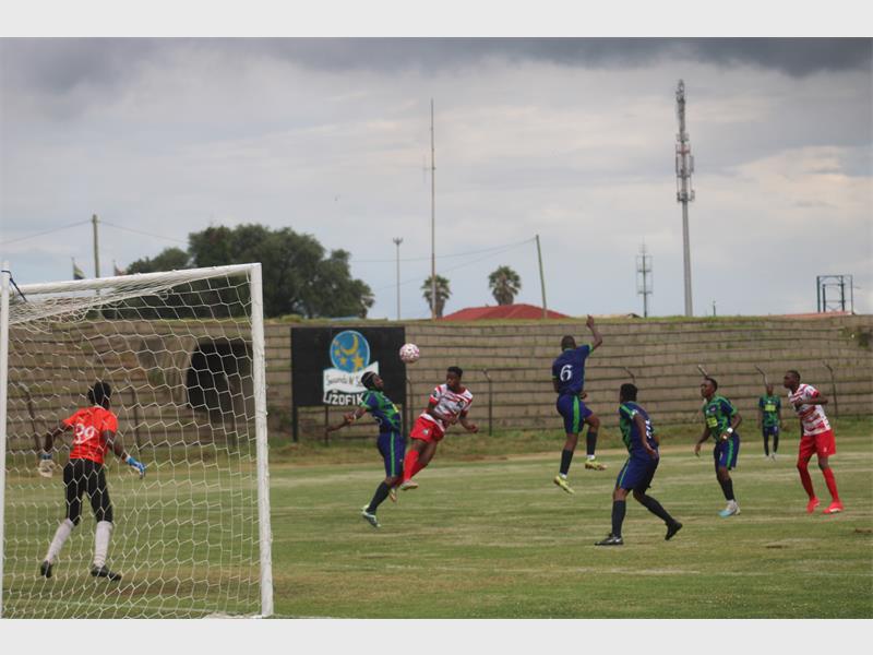 soccer players battle for the ball