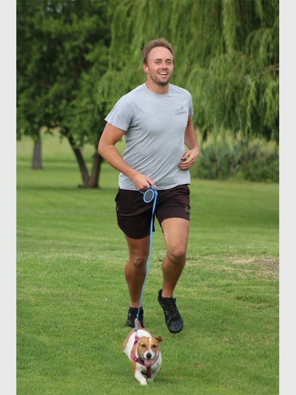 man runs with his dog in the park