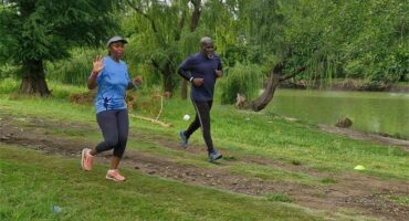 two people run in the park.
