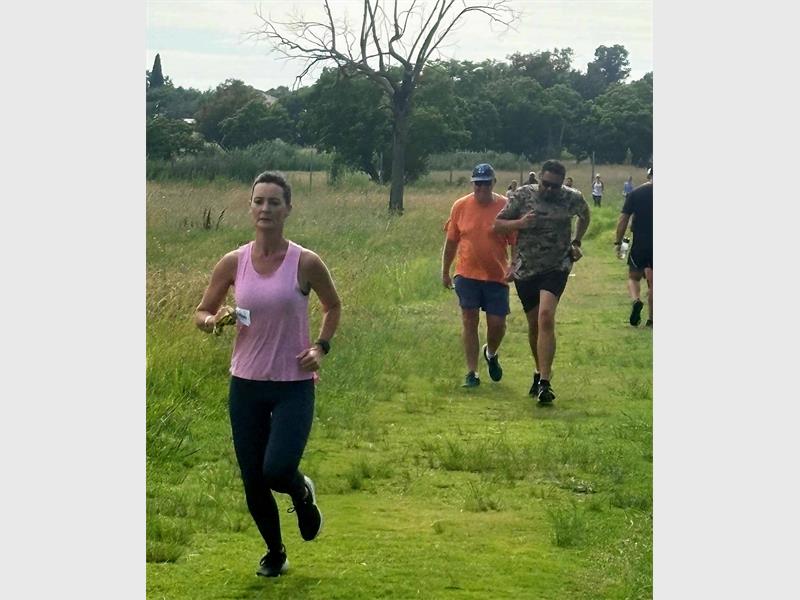 Woman in pink runs ahead of men