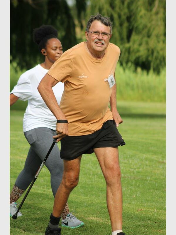 man with walking stick in the veld