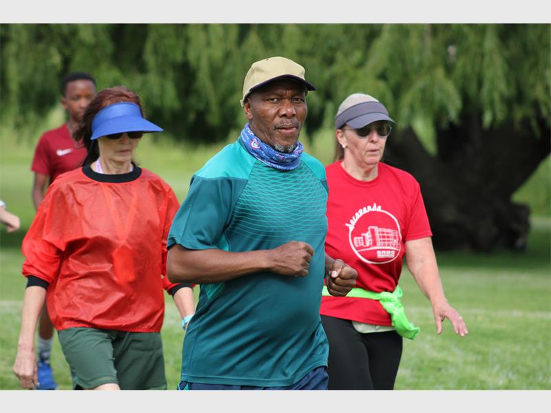 a group of people jogging in the park