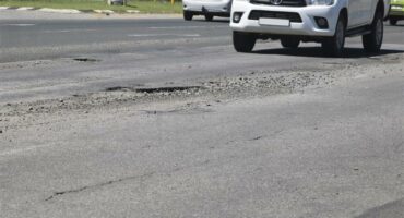 Bakkie nears a big pothole in the road