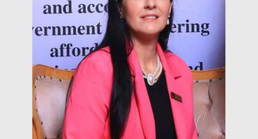 woman with long black hair wearing a pink jacket