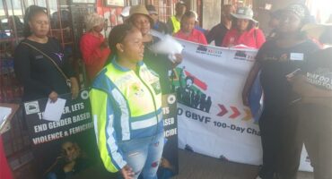 people in reflector jackets and others with a banner