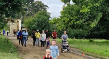 people walking on a muddy road