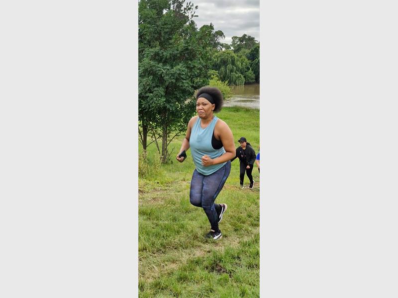 woman runs uphill in a park