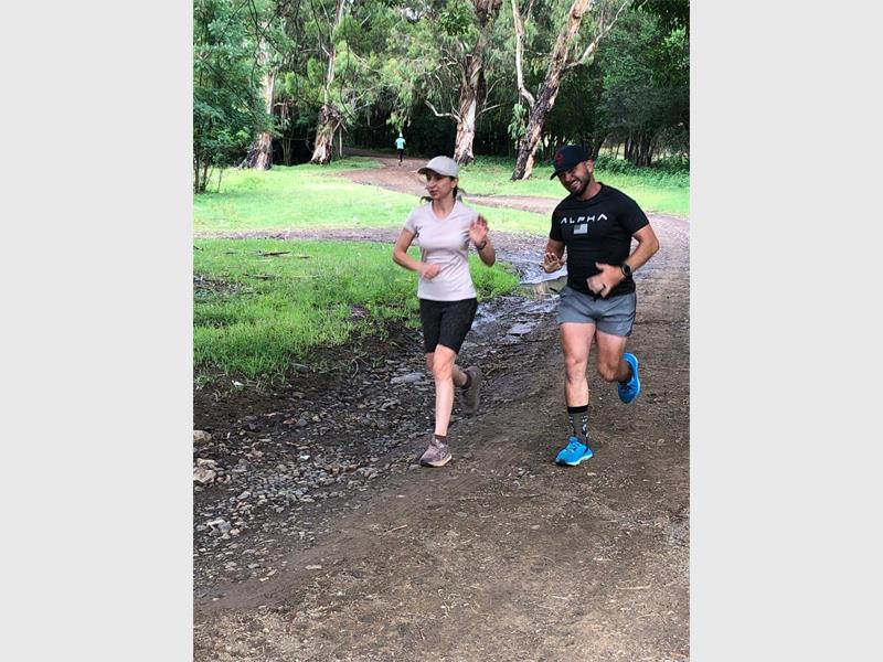 woman and man running on dirt road