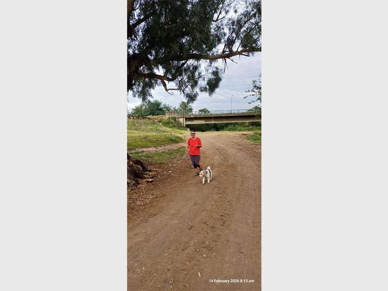 a woman with a dog on a dirt road