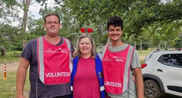 three people with pink volunteer bibs