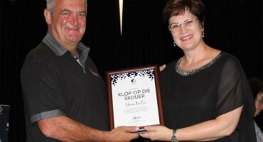 a man and a woman holding up a framed certificate