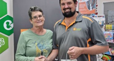 woman hands over a gift bag to a man