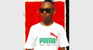 young man in a white Puma shirt and a red background