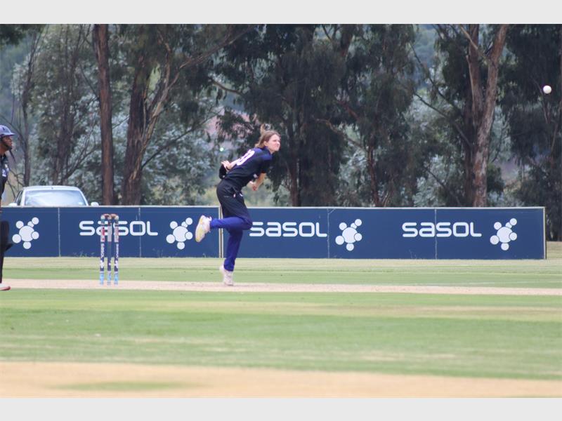 A woman bowls in a cricket match