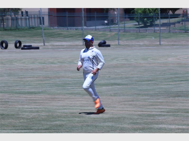cricket player with bright orange shoes