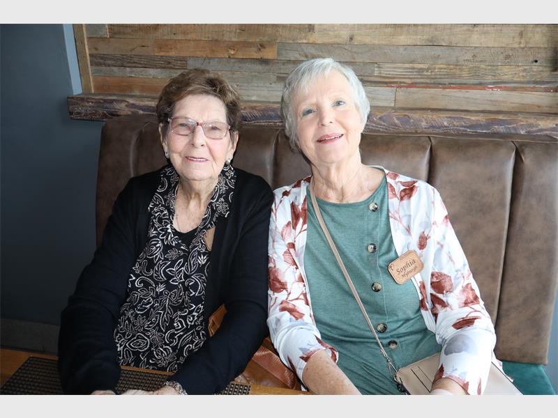 two senior women on a wooden bench