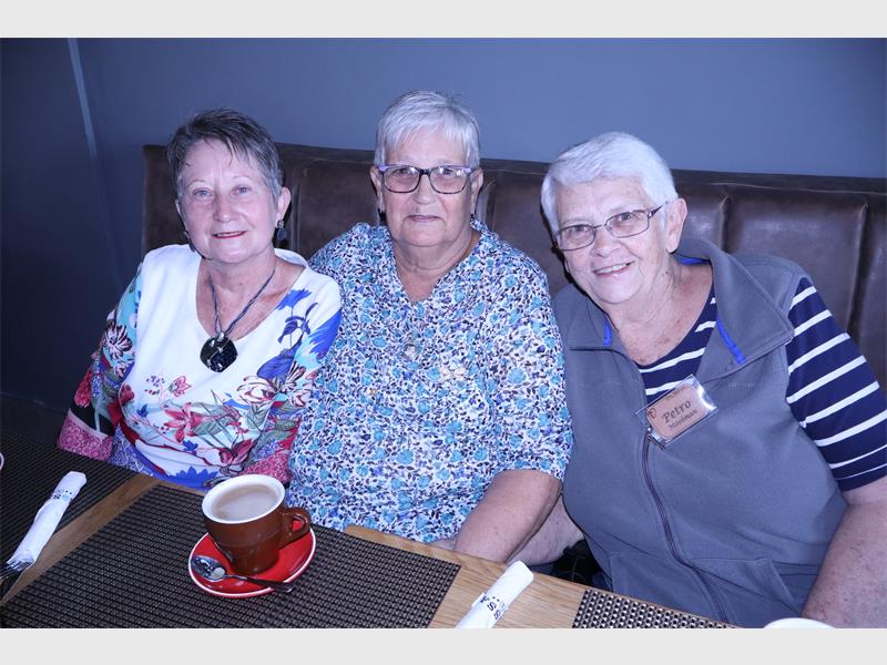 three elderly women having coffee