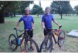 two cyclists with their mountain bikes in a park