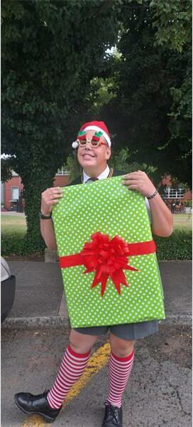 Boy is dressed as a Christmas gift