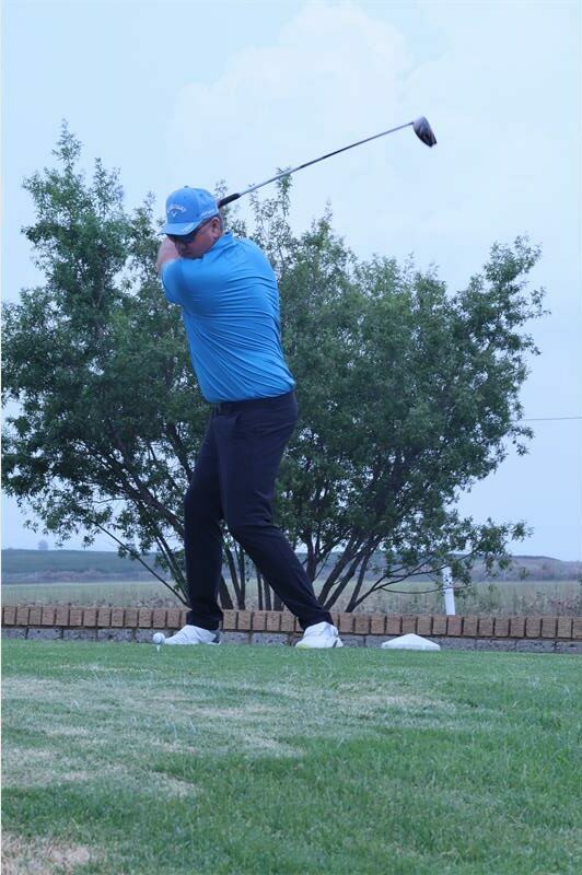 man with a blue shirt plays golf