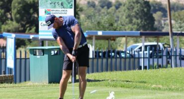 man with blue shirt tees off