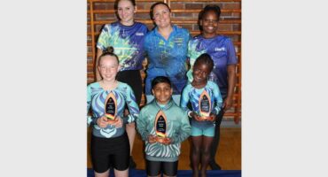 group of gymnasts and trophies